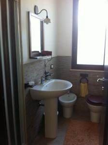 bagno con lavandino, servizi igienici e specchio di Le Villette di Consuelo a Pizzolungo