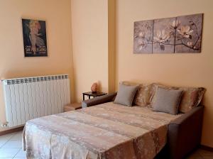 a bedroom with a bed and a painting on the wall at Casa vacanze ELISA in San Pellegrino Terme +7 photos