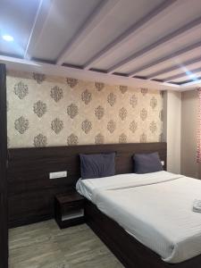 a bedroom with a large bed and a wall at HOTEL GOLDEN Inn in Bengaluru