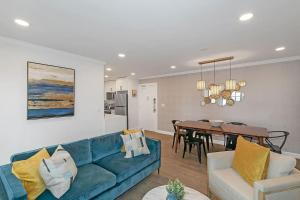 a living room with a blue couch and a dining room at Stayatl Premier 2 Bed Condo W Views! in Atlanta