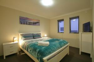 a bedroom with a bed and a tv and windows at Marina Sands in Geographe