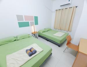 ein Zimmer mit zwei Betten und einem Schreibtisch und einem Stuhl in der Unterkunft Emilie 164 Cozy Seremban Homestay Galena Seremban Town in Seremban