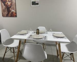 una mesa blanca con sillas blancas y una mesa con platos en Warm, Homely Apartment - 5min Away Menlyn Main, en Pretoria 25 fotos más