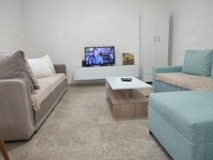 a living room with a couch and a tv at Vila Lazovi in Demir Kapija