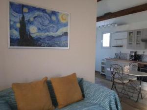 a living room with a couch and a painting on the wall at La Maison Verte in Tulette