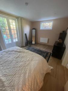 een slaapkamer met een bed, een stoel en een raam bij Maison cosy avec jardin & parking, proche Disney in Chelles