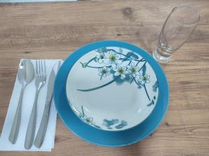 a blue and white plate on a table with a glass at Vila Lazovi in Demir Kapija