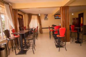 a restaurant with red chairs and tables in a room at Northern Galaxy Hotel in Isiolo