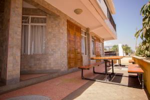 a porch with two benches and a table in front of a building at Northern Galaxy Hotel in Isiolo