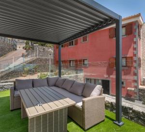awning over a patio with a couch and a table at Villa Mogaren in Vega de San Mateo