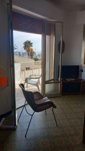 einen Stuhl in einem Zimmer mit Meerblick in der Unterkunft Domus Maregi in Marina di Ragusa