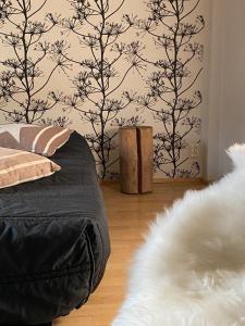 ein Schlafzimmer mit einem Bett und einer Wand mit Bäumen in der Unterkunft Ullavan pieni helmi in Kokkola