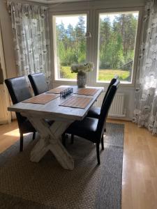 ein Esstisch mit Stühlen und ein großes Fenster in der Unterkunft Ullavan pieni helmi in Kokkola + 29 Fotos