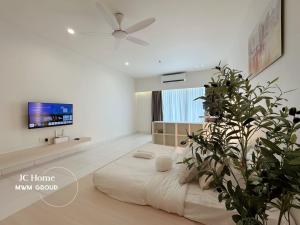 ein weißes Schlafzimmer mit einem großen Bett und einer Pflanze in der Unterkunft Bayu Marina Residence Muji Style 5min Midvalley Johor Bahru in Johor Bahru