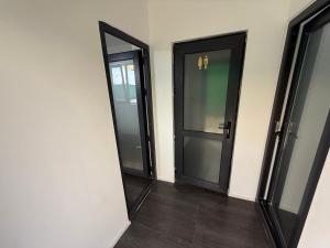 zwei schwarze Türen in einem Zimmer mit Holzböden in der Unterkunft Sax Camping Costinesti in Costinești + 15 Fotos