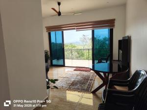 Una sala de estar con un televisor y una mesa y sillas. en Magic Destination, en Vagamon