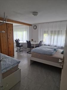 a bedroom with a bed and a table with chairs at Einliegerwohnung mit 2 Zimmern, Badezimmer, küche in Waldshut-Tiengen
