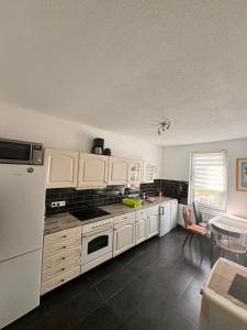a kitchen with white cabinets and a white refrigerator at Zimmervermietung Donea in Schönebeck +9 photos
