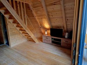 a attic room with a tv and a staircase at Fikro's Resort in Kulen Vakuf