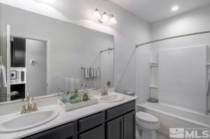 een badkamer met 2 wastafels, een toilet en een bad bij Local 3BD 3BA with WiFi Parking in Carson City +9 foto's