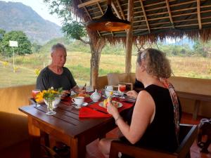 two people sitting at a table in a restaurant at Redstone Cottage Gal Oya in Galgamuwa