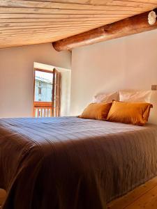 a bedroom with a large bed with orange pillows at Maison Lajouanie, 10 pers, Orelle, Val Thorens, bike in Saint-André