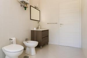 a bathroom with a toilet and a sink and a mirror at Villa Lesina Casa Vacanze in Santa Maria di Castellabate +40 photos