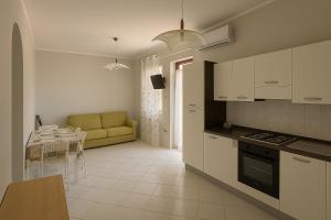 a kitchen and living room with a couch and a table at Villa Lesina Casa Vacanze in Santa Maria di Castellabate
