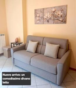 a couch in a living room with a painting on the wall at Casa vacanze ELISA in San Pellegrino Terme