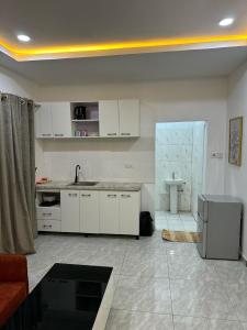 a kitchen with white cabinets and a sink at Utako Studio Apartments-City Center in Abuja