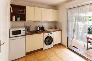 a kitchen with a washing machine and a microwave at Orangeraie du Cap d'Antibes in Antibes +17 photos