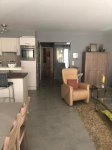 eine Küche und ein Wohnzimmer mit einem Stuhl und einem Tisch in der Unterkunft Stijlvol Appartement vlakbij Strand & Casino Vakantie Odyssey Oostende in Ostende