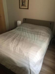 ein Bett mit einer weißen Bettdecke in einem Schlafzimmer in der Unterkunft Stijlvol Appartement vlakbij Strand & Casino Vakantie Odyssey Oostende in Ostende + 5 Fotos