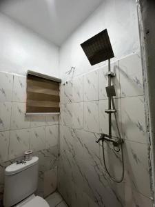 a bathroom with a shower and a toilet at Utako Studio Apartments-City Center in Abuja