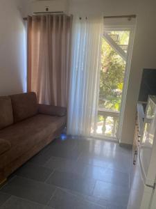 a living room with a couch and a large window at Vila Rei in Borsh