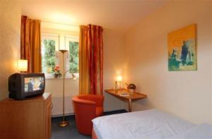 TV a/nebo společenská místnost v ubytování Hotel Zur Erholung & Restaurant Amme's Landhaus