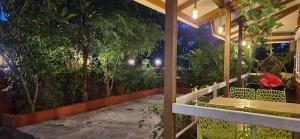 a porch of a house with a garden at night at Gulmohar Villa tamhini ghat, Kolad Rafting 