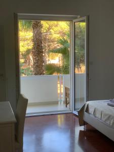 a bedroom with a sliding glass door with a palm tree outside at B&B Madreperla in Gallipoli