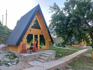 a log cabin with a pitched roof and red chairs at Camp Magic View in Mojkovac +25 photos