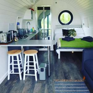 a tiny house with a kitchen and a bed at Orielton Fach Farm - Cosy rural lodge in beautiful surroundings in Pembrokeshire