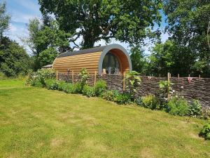 a small house in a garden with a fence at Orielton Fach Farm - Cosy rural lodge in beautiful surroundings in Pembrokeshire +7 photos
