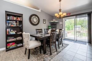 莱昂斯黑德Huron retreat, near beach & pet friendly的一间有桌子、椅子和钟的餐厅