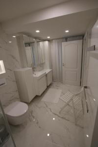 a white bathroom with a toilet and a sink at Schicke Ferienwohnung für 2 in Niederkalbach +9 photos