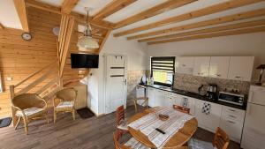 a kitchen and dining room with a table and chairs at Domki Wilcza A in Wilcza