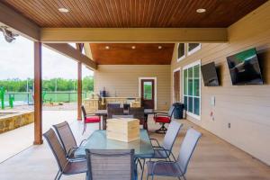 a patio with a table and chairs and a tv at Retreat Abilene A Retreat Dfw Experience in Ovalo