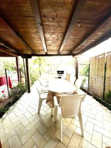 una mesa y sillas en un patio con techo de madera en FAGR-OTT01T BELLA CASA ad un passo dal mare, en Agrustos