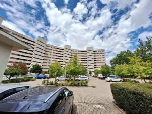 a parking lot with cars parked in front of a large building at Villa Horizon-Siófok in Siófok