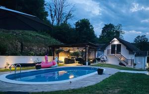 a swimming pool in a yard with a house at Apartman Maslina in Kosjeric