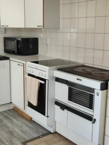 una cocina con estufa y microondas en Koivistonpiha farmstay, en Valkeakoski 22 fotos más