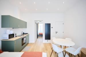 a kitchen with a table and white chairs at Apartment Duden 1 in Brussels